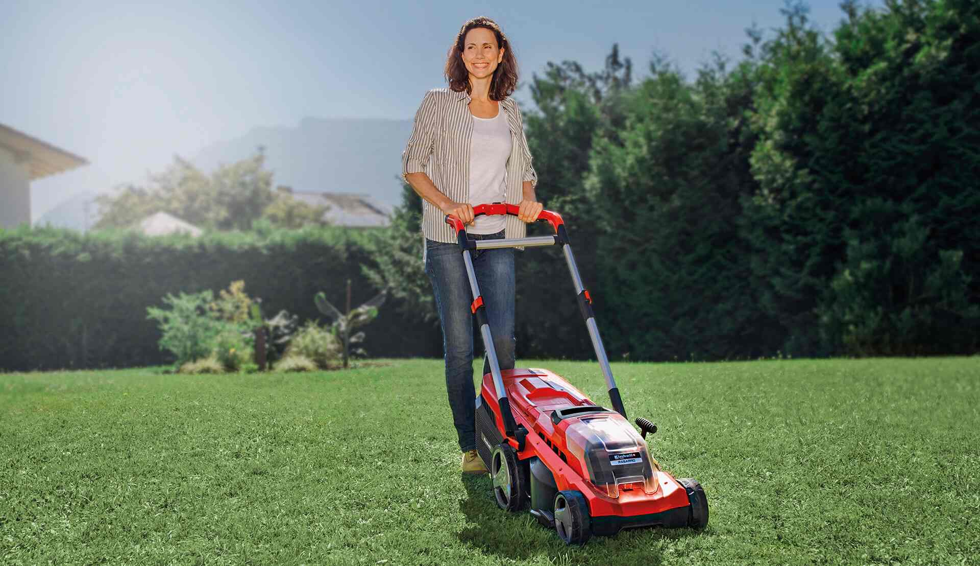 femme passe la tondeuse à gazon sans fil dans son jardin-compressed